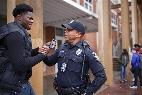 School resource officer Derrick Hammond greets senior Kemari Averett at Grady High School in Atlanta. —Melissa Golden/Redux f 